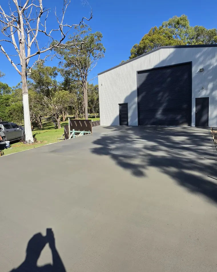 Wide concrete apron poured in front of a large shed